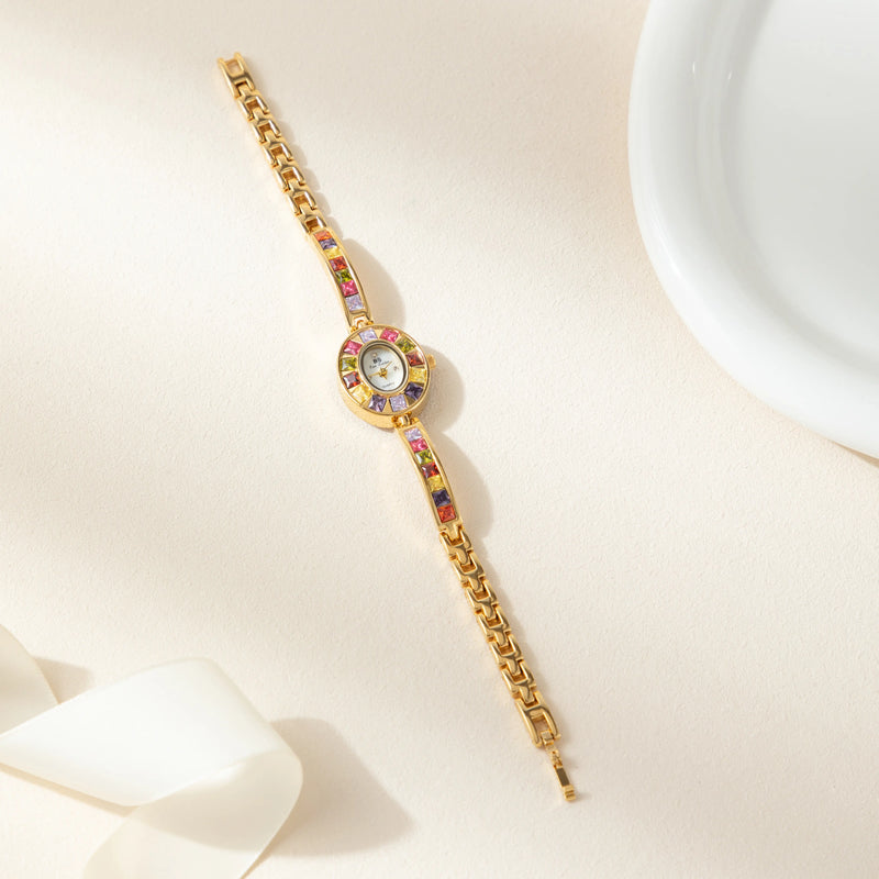 Amelie – Goldene Uhr mit Kristallrahmen.