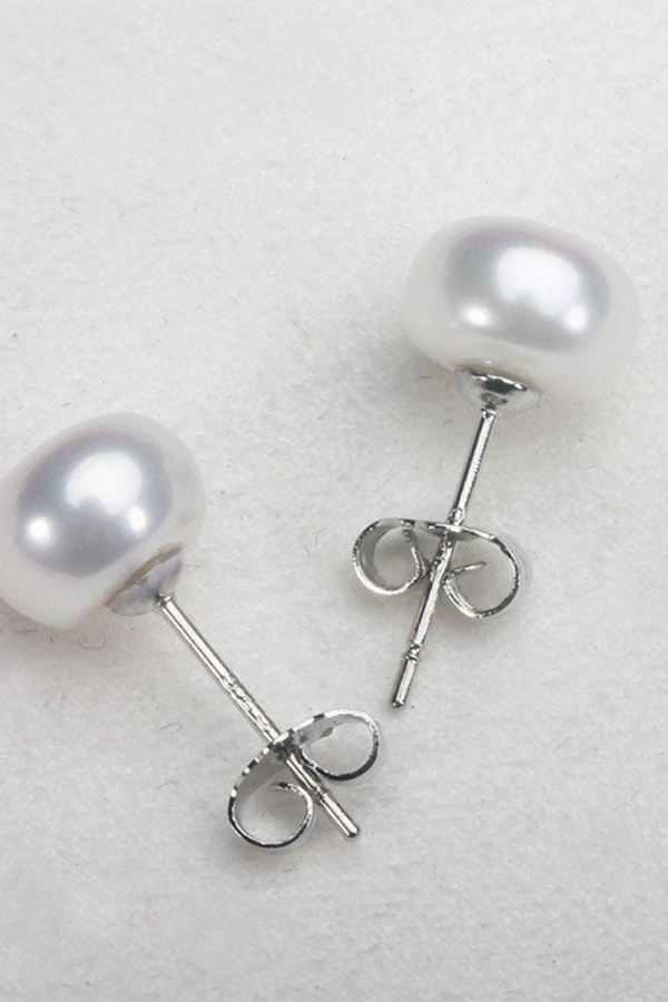 Frieda – Goldene Ohrstecker mit Perlen und klarer Form.