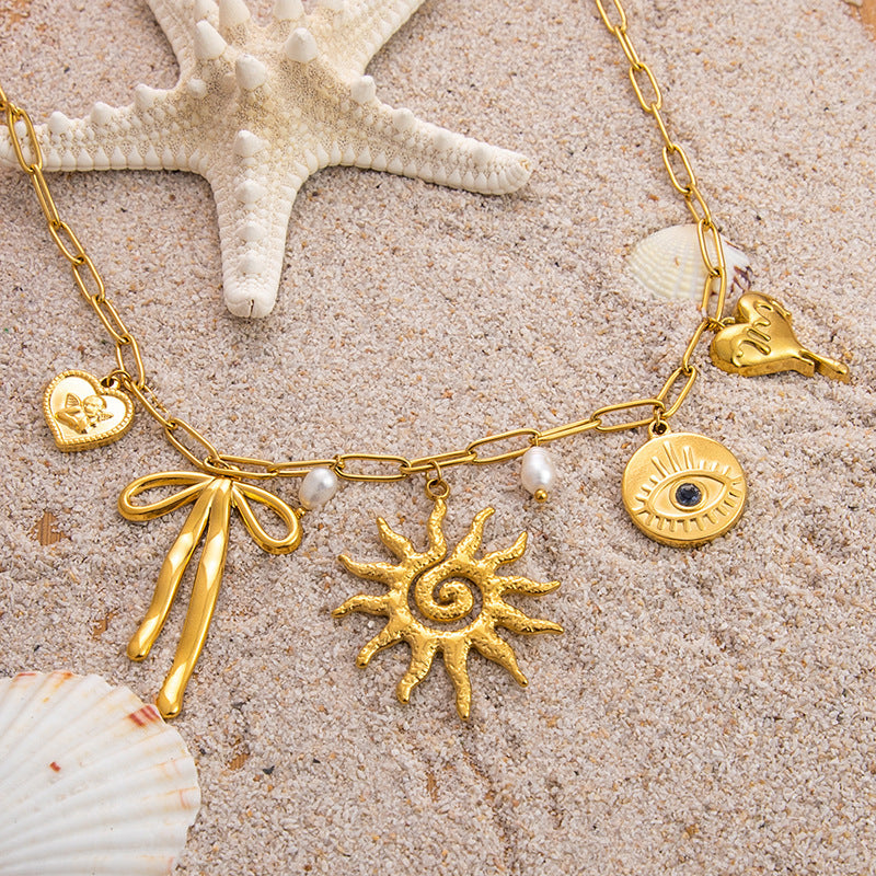 Emilia – Zarte goldene Kette mit kleinen Anhängern.