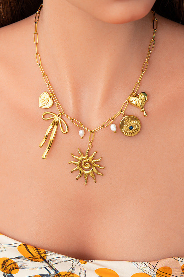 Emilia – Zarte goldene Kette mit kleinen Anhängern.