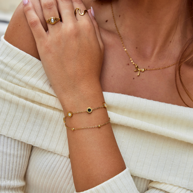Carla – Ein zartes, goldfarbenes Armband mit kontrastreichen Rund-Elementen.