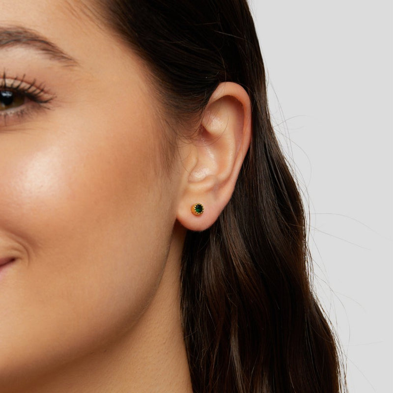 Viktoria – Goldene Ohrstecker mit grünem Stein.