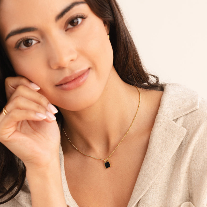 Dorothea – Goldene Kette mit grünem Edelstein.