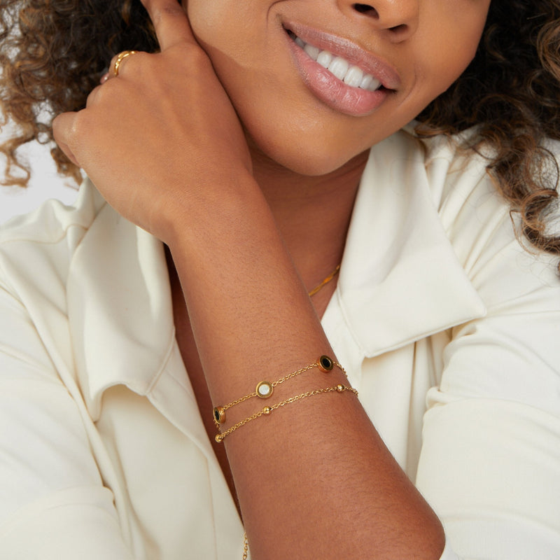 Carla – Ein zartes, goldfarbenes Armband mit kontrastreichen Rund-Elementen.